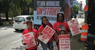 CWA members hold strike signs with mobile billboard at college football solidarity action