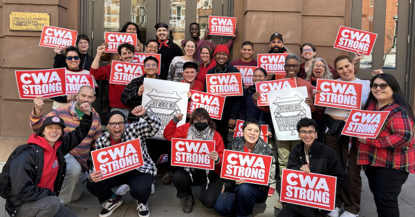 A group of workers pose for a photo holding signs that say "CWA Strong."