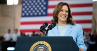 kamala harris standing at a podium in front of an American flag