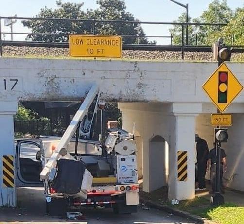 AT&T lift truck stuck under an overpass